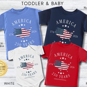 May include: Four toddler and baby shirts in blue, navy, white, and red. Each shirt features the word "AMERICA" above a map of the United States with a flag design, the years 1776 and 2026, and "250 YEARS".