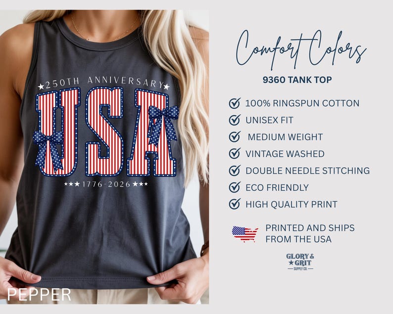 May include: A dark gray tank top with the word "USA" in red and white stripes, accented with blue bows. The text "250TH ANNIVERSARY" and "1776-2026" are above and below the word "USA". The tank top is part of the Comfort Colors collection.