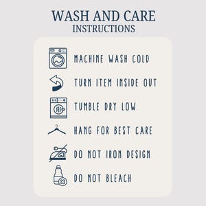 May include: Cream-colored card with navy blue text detailing wash and care instructions. Includes icons for machine washing cold, turning inside out, tumble drying low, hanging for best care, and warnings against ironing and bleaching.