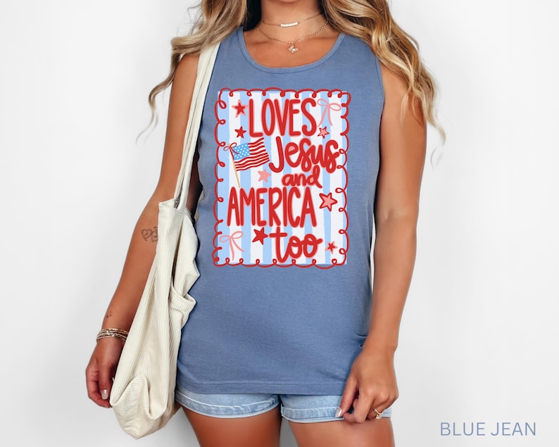K&ouml;nnte beinhalten: Ein blaues Jeans-Tanktop mit dem Text "Loves Jesus and America too" in einem rot-wei&szlig;en Design. Das Design enth&auml;lt eine kleine amerikanische Flagge und Sterne. Das Tanktop ist &auml;rmellos und hat einen Rundhalsausschnitt.