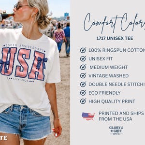 May include: White unisex t-shirt with a patriotic "USA" design in red, white, and blue, celebrating the 250th anniversary of 1776-2026. The shirt is labeled "Comfort Colors 1717 Unisex Tee" and made of 100% ringspun cotton.