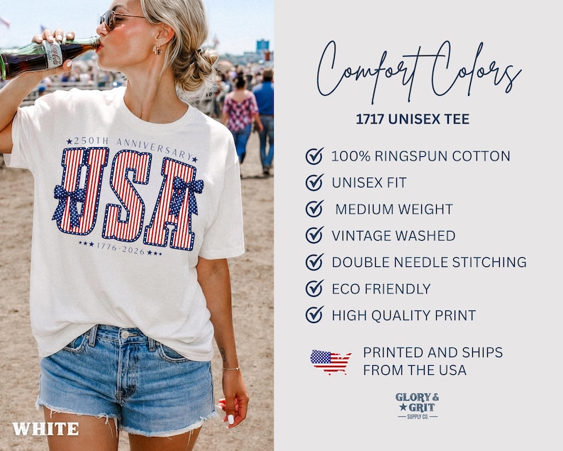 May include: White unisex t-shirt with a patriotic "USA" design in red, white, and blue, celebrating the 250th anniversary of 1776-2026. The shirt is labeled "Comfort Colors 1717 Unisex Tee" and made of 100% ringspun cotton.