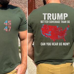 May include: A green t-shirt with a red, white, and blue American flag design on the front and the text "TRUMP BETTER COVERAGE THAN 5G CAN YOU HEAR US NOW?" with a map of the United States on the back.