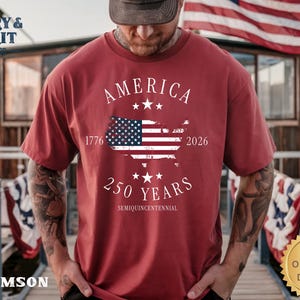 May include: Crimson t-shirt with the text "AMERICA" and a map of the United States with the American flag. The shirt also features the text "1776 2026 250 YEARS SEMIQUINCENTENNIAL". The shirt has a "G&G ORIGINAL DESIGN" logo.