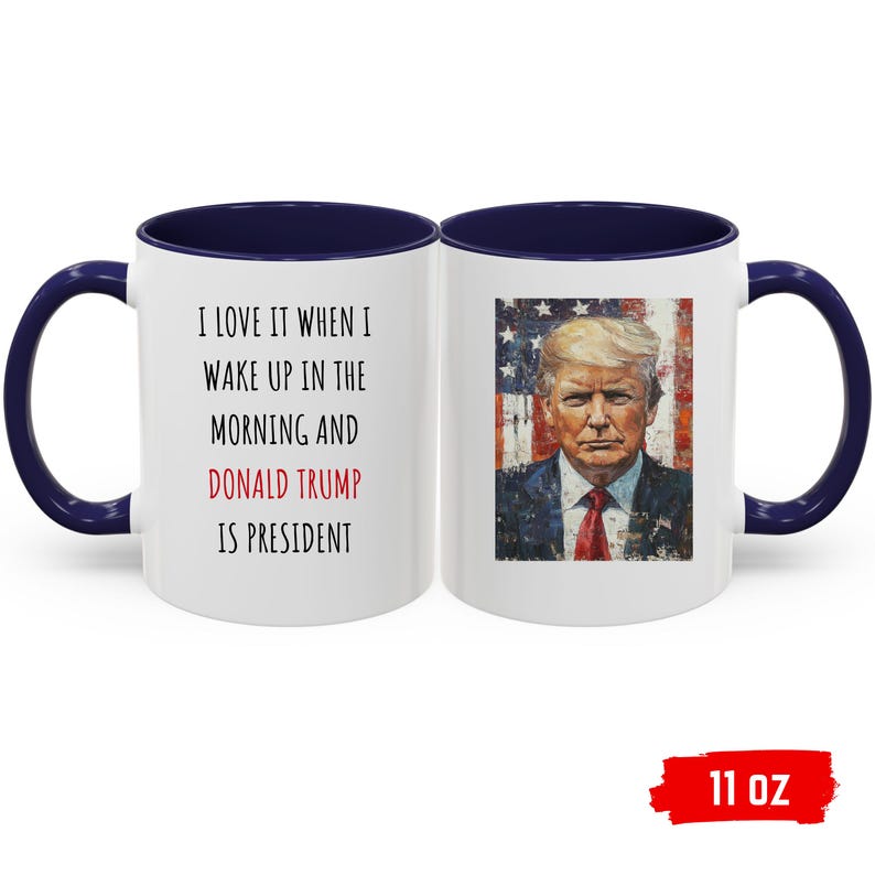 K&ouml;nnte beinhalten: Wei&szlig;er Keramikbecher mit marineblauem Innenraum und Griff. Der Becher zeigt den Text "I LOVE IT WHEN I WAKE UP IN THE MORNING AND DONALD TRUMP IS PRESIDENT" und ein Portr&auml;t von Donald Trump. Fassungsverm&ouml;gen: 325 ml.