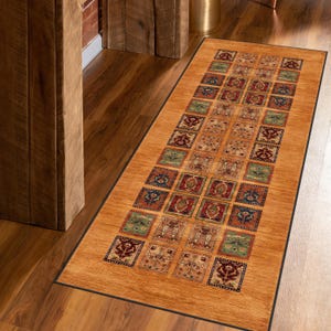 May include: A brown and beige patterned runner rug with a black border. The rug has a geometric design with squares and rectangles.