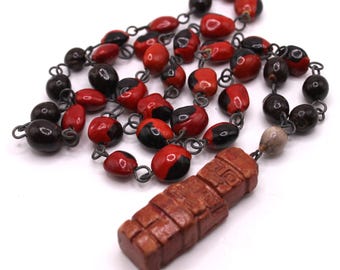 Collar inca peruano de la década de 1910 con cuentas étnicas y colgante de deidad. Amuleto de la buena suerte rojo y negro.