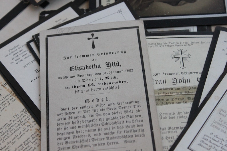 May include: A black and white mourning card with a cross at the top and the text "Zur frommen Grinnerung an Elisabetha Hild, welche am Sonntag, den 31. Januar 1892, in Detroit, Mich., in ihrem 62. Lebensjahre, felig im Herrn entschlief."  The card also includes a prayer.