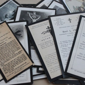 May include: A collection of vintage memorial cards with black borders and white text. The cards feature religious imagery, including crosses and prayers. The text includes the names of the deceased, dates of birth and death, and religious quotes.