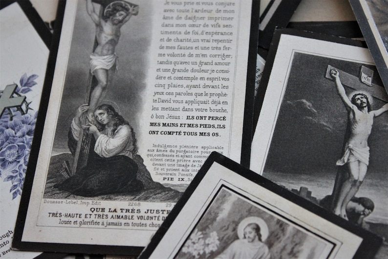 May include: Two vintage religious cards with black borders. The first card features a black and white illustration of Jesus on the cross. The second card features a black and white illustration of a woman kneeling in prayer. The text on the second card reads "Que la tres juste tres haute et tres aimable volont&eacute; de lou&eacute;e et glorifi&eacute;e &agrave; jamais en toutes choses".