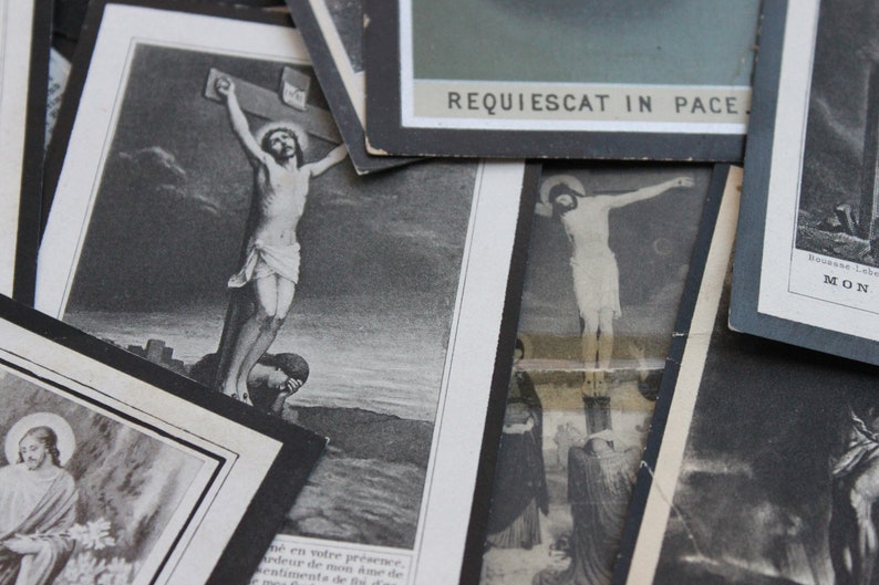 May include: A collection of black and white religious cards featuring images of Jesus Christ on the cross. The cards have a vintage feel and are printed with the text "REQUIESCAT IN PACE".