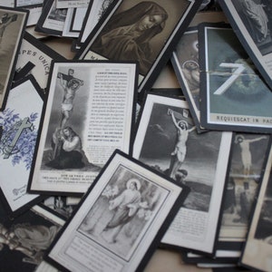 May include: A collection of vintage religious cards with black and white images of Jesus Christ on the cross, Mary, and other religious figures. The cards have a distressed look and are printed on thick paper.