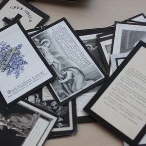 May include: A collection of black and white religious cards with images of crosses and religious figures. The cards have black borders and are printed with text in a variety of fonts.