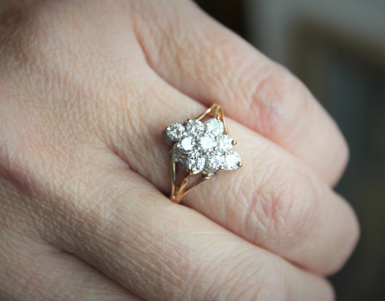 May include: A gold ring with a cluster of small diamonds set in a flower shape.