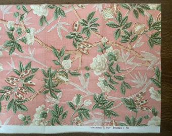 May include: Pink fabric with a floral pattern featuring white flowers and green leaves. The fabric has a repeating pattern of flowers and leaves. The fabric is called "Tamarindo" and is by the brand "MMW Branch & File".