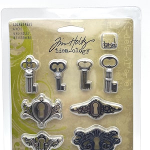 May include: A package of Idea-ology Locket Keys, keyholes, and fasteners. The package includes four keys, four keyholes, and eight fasteners. The keys and keyholes are silver-colored and have an antique design. The package is labeled "Idea-ology" by Tim Holtz.