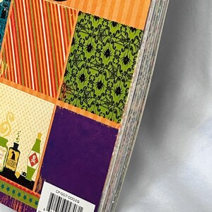May include: A stack of decorative paper sheets featuring Halloween-themed patterns including orange stripes, green spider webs, and purple squares. A white barcode label with the text CP-007-00029 and PROVO, UT 84604 is visible on the bottom corner.