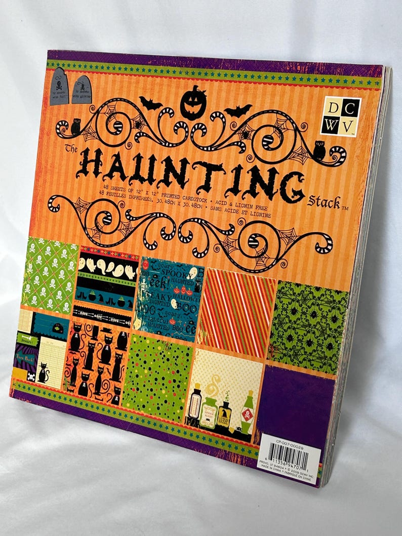 May include: A square stack of 48 sheets of 12 inch by 12 inch printed cardstock titled The Haunting Stack. The cover features orange and purple stripes, black silhouettes of pumpkins, bats, and cats, and various Halloween-themed patterns.