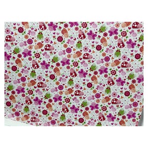 Op de afbeelding: Een wit vel inpakpapier met een herhalend patroon van cartoonkikkers, roze vlinders, lieveheersbeestjes, slakken, kleine rode bloemen en witte enveloppen met kleine rode hartjes verspreid over het oppervlak in een kleurrijk ontwerp.
