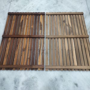 Può includere: Due tappeti rettangolari in legno, ciascuno con doghe verticali e supporti orizzontali. Un tappeto è un mix di tonalità marroni, l'altro è marrone chiaro. I tappeti sono probabilmente per un bagno o un ambiente esterno.