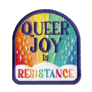 May include: An embroidered patch with a rainbow background and a dark purple border. The text QUEER JOY is stitched in dark purple, followed by the word is, and the word RESISTANCE in multicolored letters over a white cloud shape.