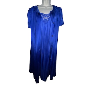 May include: A vibrant blue vintage nightgown and robe set. The nightgown features a square neckline with delicate lace detailing. The robe has short sleeves and a button-down front. The set is made of a silky, flowing fabric.