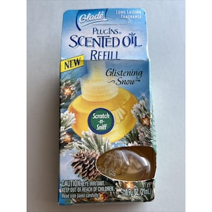May include: A Glade Plugins Scented Oil Refill in a white box with a blue and green design. The refill is for the Glistening Snow scent. The box has a "Scratch-n-Sniff" area. The refill is 7.10 fl oz (21 ml).