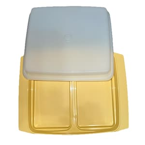 May include: A yellow rectangular food storage container with a divided base and a light blue lid. The lid has a circular indentation in the center. The container is made of plastic.