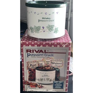 May include: A white Rival Potpourri Crock electric simmering cooker with a dark green rim and a painted ivy and berry vine pattern. The cooker sits atop its original square cardboard box, which features product imagery and text labels.