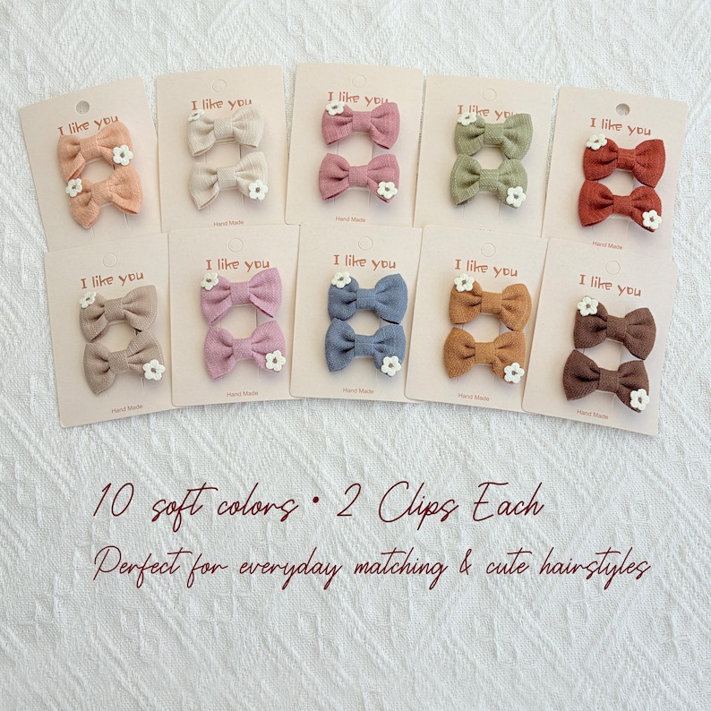 May include: Ten pairs of hair clips in soft colors, each with a bow and a small white flower. The cards read "I like you". The text on the image says "10 soft colors &bull; 2 Clips Each".