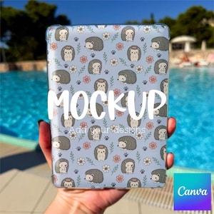 May include: A light blue tablet case with a repeating pattern of cartoon hedgehogs, pink flowers, and paw prints. The word "MOCKUP" is displayed in large white letters. The text "Add your designs" is also visible.