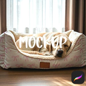 May include: A dog bed with a cream-coloured interior and a light pink bow pattern on the exterior. A sleeping golden Labrador rests inside the bed. The bed has a brown leather tag.