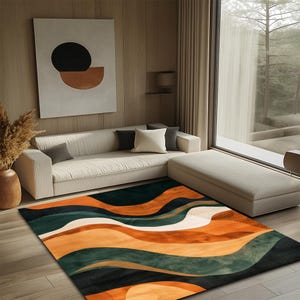 May include: A rectangular area rug with a wavy pattern in shades of orange, green, and white. The rug is placed on a wooden floor in a living room setting, with a cream-colored sofa and a large window in the background.