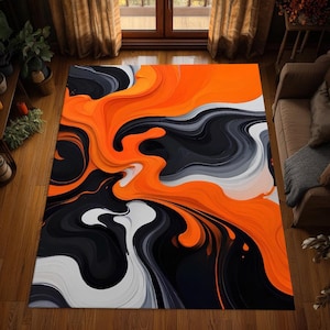 May include: A rectangular area rug featuring a fluid, marbled pattern of vibrant orange, deep black, and shades of white and gray. The design consists of swirling, liquid-like waves that stretch across the entire surface of the floor covering.