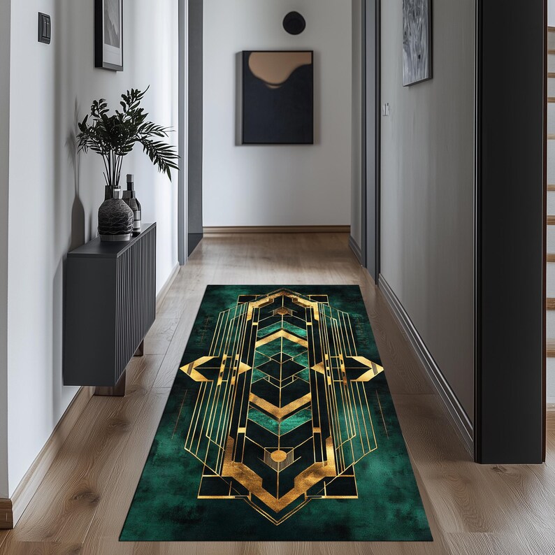 May include: A green and gold geometric patterned runner rug with a modern design. The rug is placed in a hallway with dark grey walls and wooden floors.