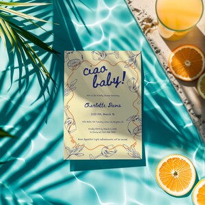 May include: A yellow baby shower invitation with a blue and orange design. The invitation says "Ciao Baby!" and includes the details for a baby shower for Charlotte Davis. The invitation is on a blue background with orange slices and a glass of orange juice.