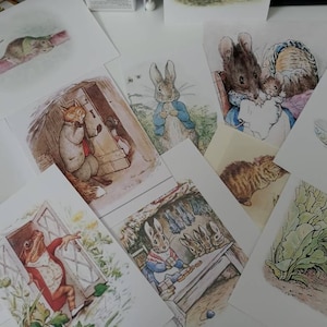 May include: A collection of vintage illustrated cards featuring various animals from the Peter Rabbit series. The cards depict a rabbit, a frog, a mouse, a fox, a cat, and a squirrel.