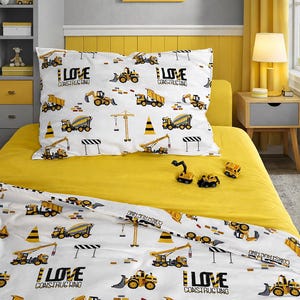 May include: A yellow and white construction-themed bedding set with a matching pillowcase. The set features illustrations of construction vehicles and the text "I Love Constructing". A framed picture of a yellow car hangs above the bed.