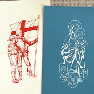 Puede incluir: Dos tarjetas de felicitación vintage. Una es de color crema con una ilustración roja de un caballero, un boy scout y una bandera. La otra es de color verde azulado con una ilustración blanca de María y el niño Jesús.