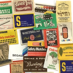 May include: A collection of vintage matchbox labels with various designs and text. The labels feature brands like "Consort Safety Match", "Roast Inn", "Whitbread Pale Ale", and "Waitrose safety matches". The labels are in various colors.