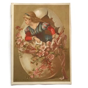 Tarjeta comercial francesa antigua de Pascua: Niña saliendo de un huevo con flores y una carta (c. 1900)