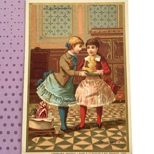 May include: Vintage illustration featuring two young girls in period clothing. One girl is offering a plate with a yellow object to the other. The image has text at the top and bottom, and is set against a background of a room with a checkered floor.