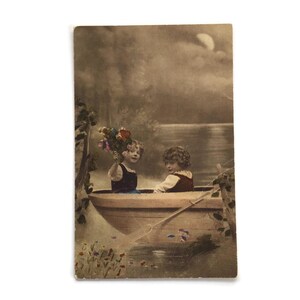Cartolina antica – Bambini dipinti a mano in barca a remi con fiori / Scena di lago fantasy al chiaro di luna, primi anni del 1900