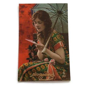 Postal vintage de los años 20: Dama francesa con sombrilla y carta. Fotografía art déco coloreada a mano.
