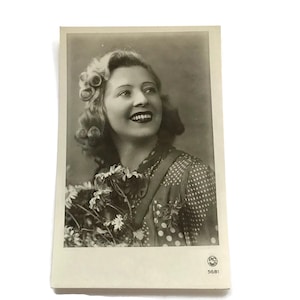 Postal francesa antigua: Mujer sonriente con flores, foto glamurosa de los años 40
