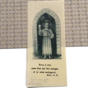 May include: Vintage religious card featuring an illustration of a figure in a robe holding a light and a book, standing in an arched doorway. The card has French text at the bottom, with the words "Venes à moi, vous tous qui êtes chargés, et je vous soulagerai. Math., XI, 28."