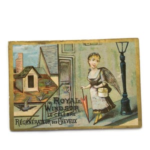 Cartão de visita francês antigo – Criança alada com cesto e guarda-chuva sob poste de luz (c. 1890)