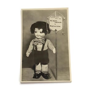 Postal vintage – Muñeca de 1939 con cartel – RPPC holandés de Bond Zonder Naam