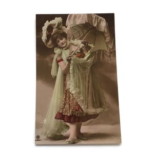 Postal francesa antigua: Dama con sombrilla de la Belle Époque. Retrato teatral coloreado a mano, c. 1900.