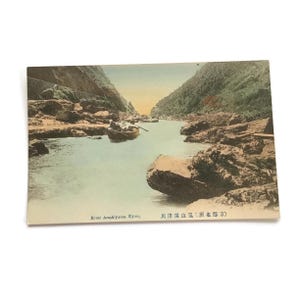 Postal japonesa antigua: río Arashiyama, Kioto: vista panorámica coloreada a mano
